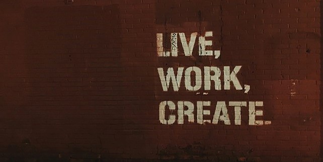 Red brick wall with quote "Live, Work, Create".