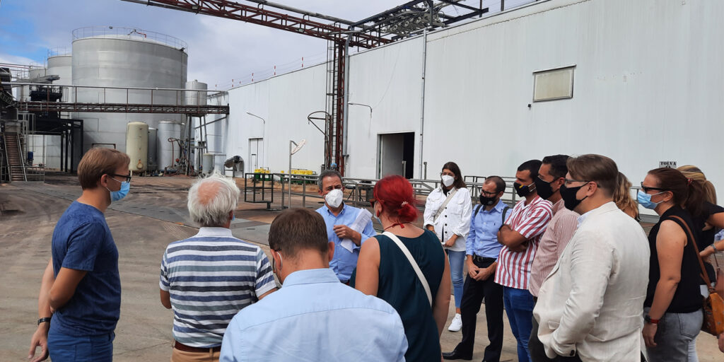 Group of people visiting a winery plant and listening to a presentation.