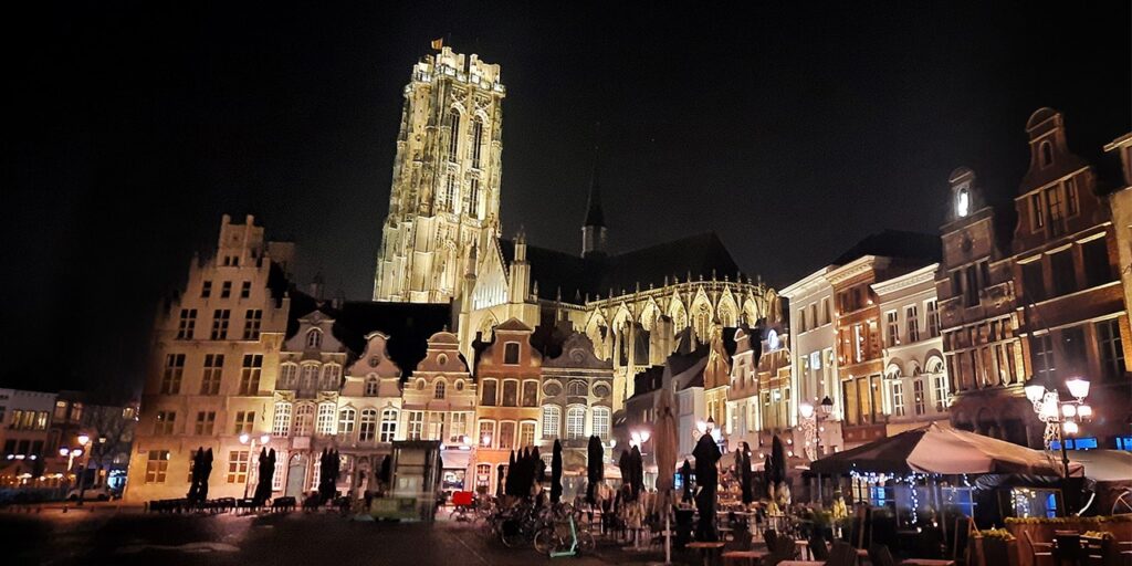 yökuva Mechelenin kaupungin keskustorilta. Kuvassa näkyy valaistuja rakennuksia ja taka-alalla valaistu St.Rumbold-katedraali 