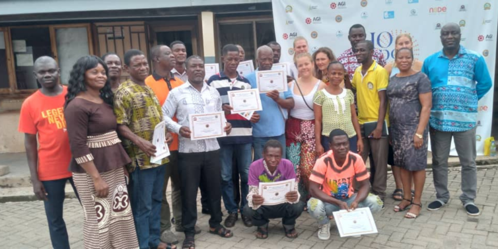 A group of people standing outside a building. Some of them are holding certificates on their hands.]