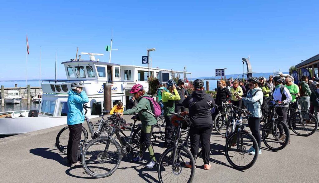 [Alt-teksti: Suuri joukko pyöräilijöitä pyörineen on sataman ranta-alueella odottamassa pääsyä laivaan.]
