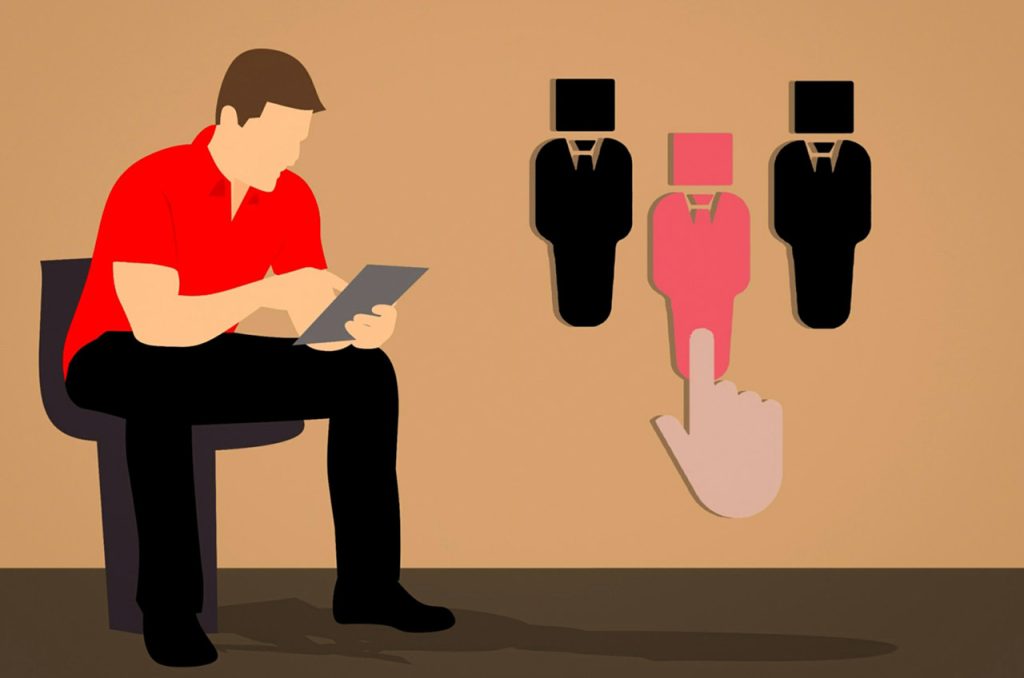 (alt-teksti: Mies istuu tuolilla ja näyttää hakevan työpaikkoja tietokoneeltaan. Kuvassa on myös kolme ihmishahmoa ja sormi osoittaa niistä yhtä)