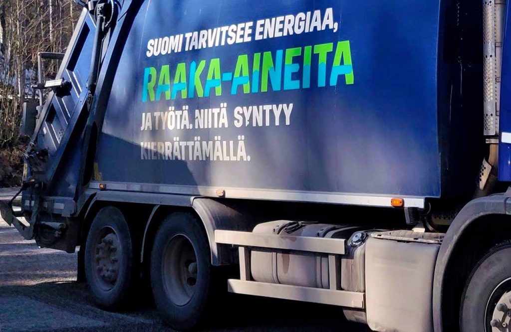 [ALT: Jätteenkeräysauto, jonka kyljessä lukee ”Suomi tarvitsee energiaa, raaka-aineita ja työtä. Niitä syntyy kierrättämällä”.]