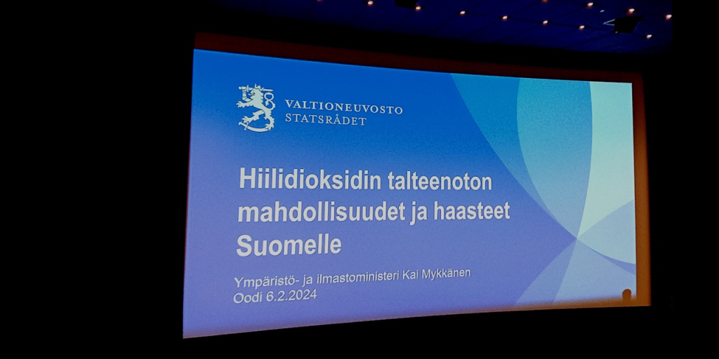 Valkokankaalle heijastettu dia, jossa lukee "Hiilidioksidin talteenoton mahdollisuudet ja haasteet Suomelle. Ympäristö- ja ilmastoministeri Kai Mykkänen. Oodi 6.2.2.2024".