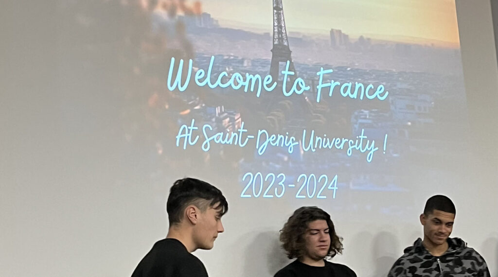 [Alt text: three students having a presentation, the text welcome to france at saint-denis-university.]