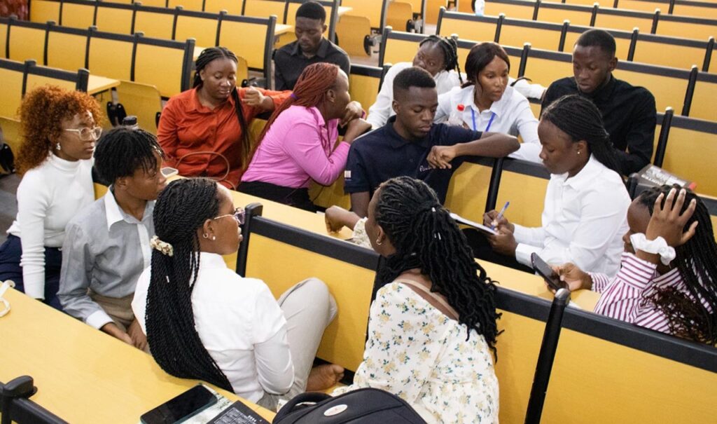 [Alt text: a group of young black students in a lecture hall.]