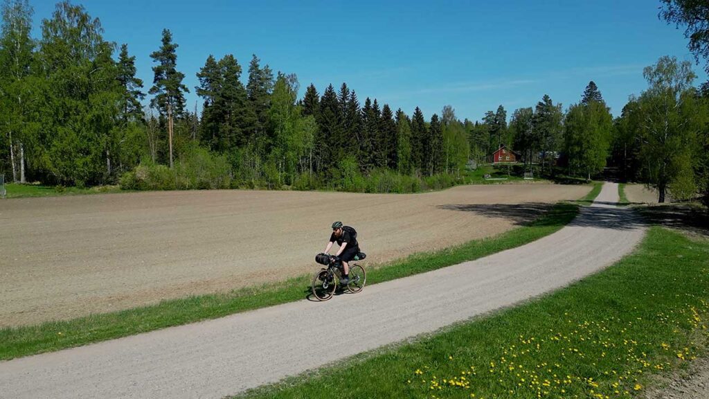 [Alt-teksti: maantie maalaismaisemassa, tiellä etenemässä pyöräilijä.]