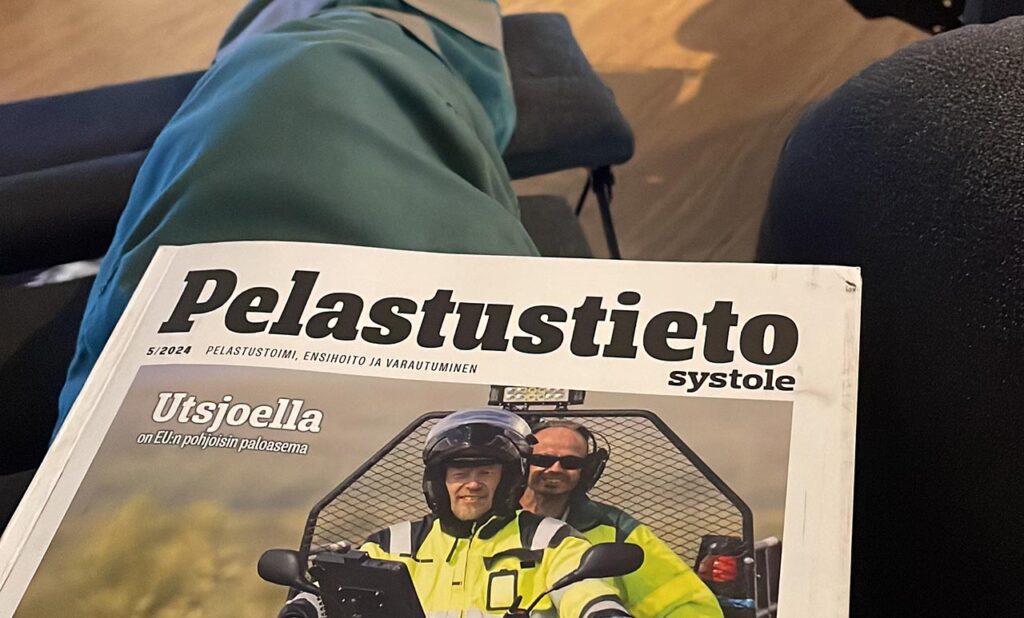 [Alt-teksti: Pelastustieto-lehti henkilön sylissä, kansikuva näkyvillä.]