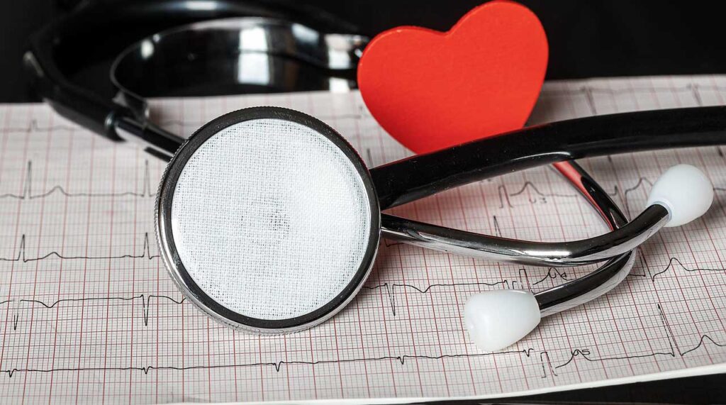 [Alt-teksti: Stetoskooppi ja punainen sydän EKG-tulosteen päällä.]
