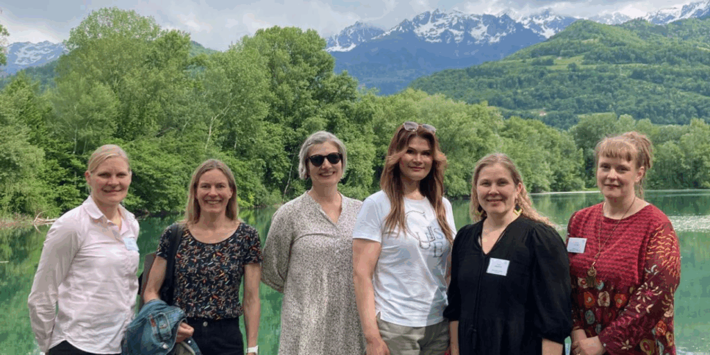 Six people standing in front of a lake view.