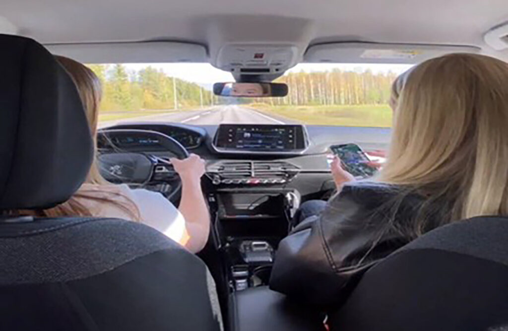 [Alt text: two persons in a car.]