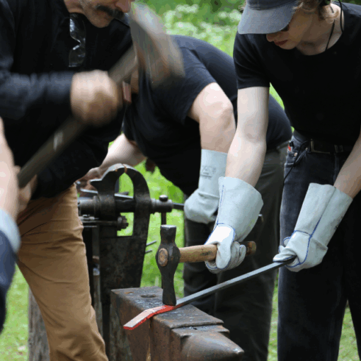 Students hammering iron outdoors