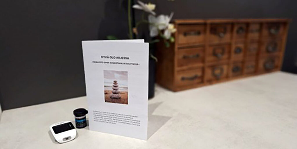 Diabetespotilaan omahoidon opas -lehtinen ja verensokerin mittauslaite.