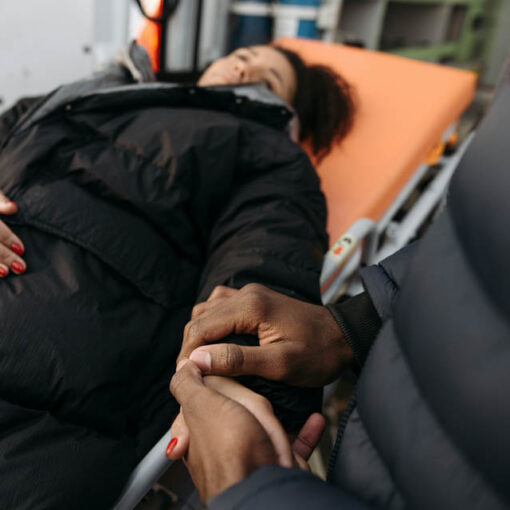 [alt-teksti: puoliso pitää kädestä kiinni matkalla synnyttämään olevaa puoliosaan.]