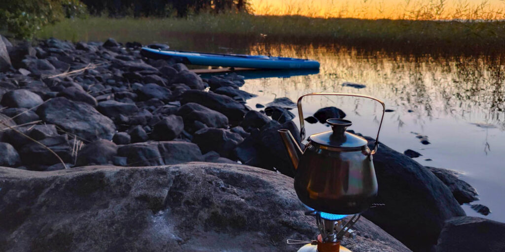 [Alt-teksti: termospannu lämpeää kivikossa järven rannalla.]