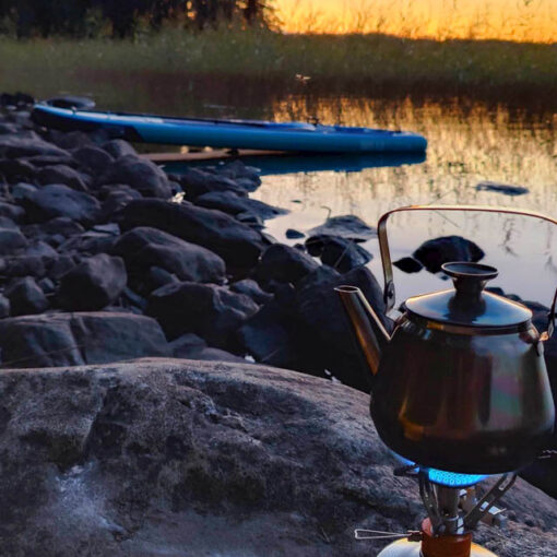 [Alt-teksti: Termospannu lämpeää kivikossa järven rannalla.]