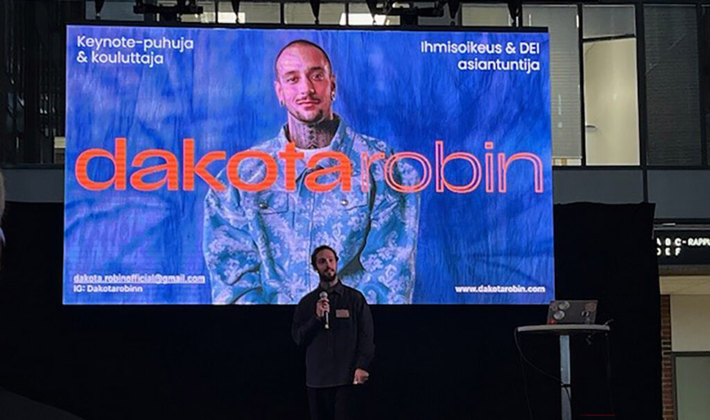 [Alt-teksti: henkilö pitää presentaatiota luentotilassa.]