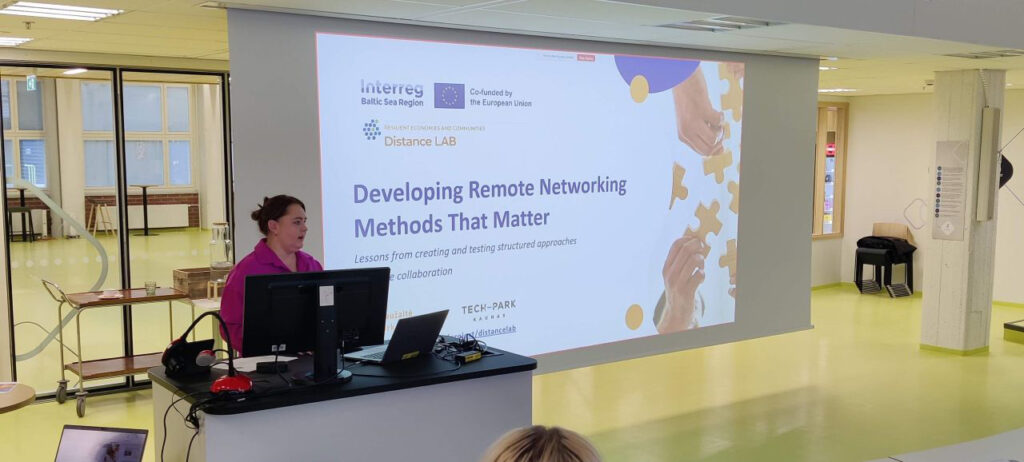 [Alt-teksti: henkilö pitämässä presentaatiota suuressa luentotilassa.]