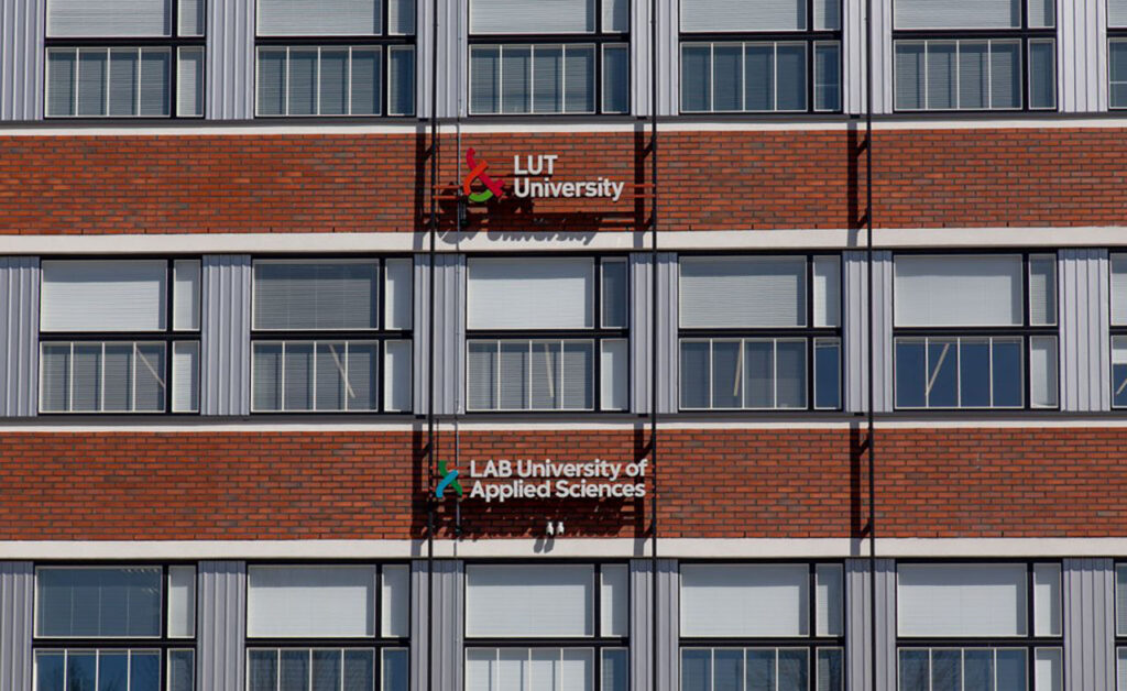 [Alt-teksti: tiiliseinää ja ikkunoita monessa kerroksessa, seinässä tekstit lut university ja lab university of applied sciences.]