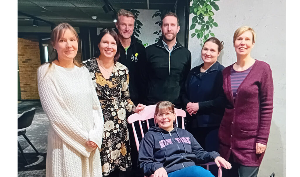 [Alt-teksti: seitsemän hymyilevää henkilöä ryhmäkuvassa.]