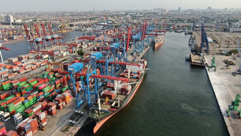 [Alt text: a large industrial harbour view with thousands of containers waiting to be loaded with cranes.]