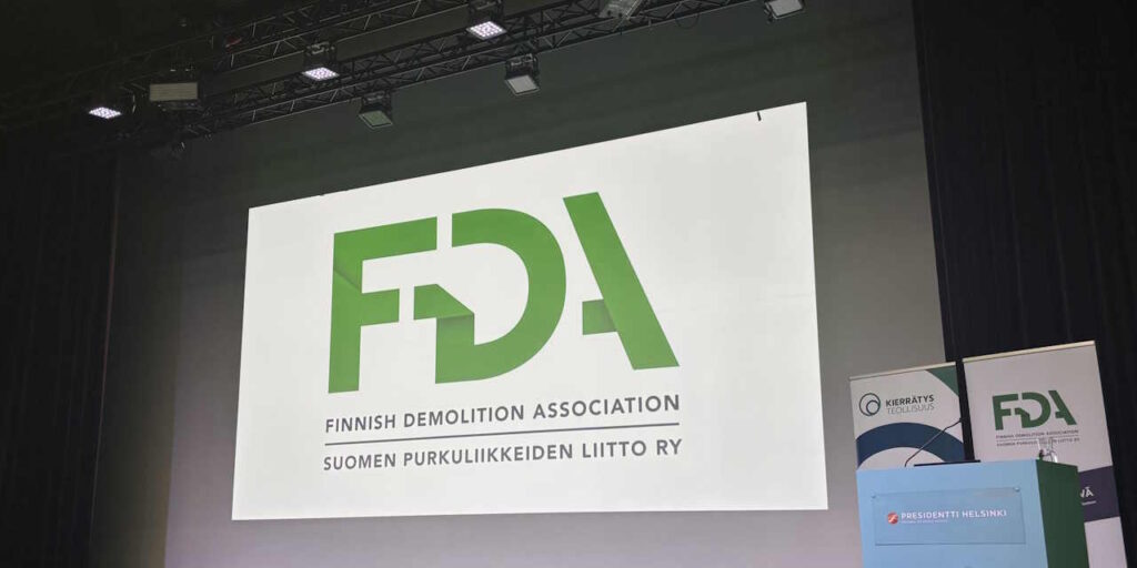 Valkokankaalle heijastettu Suomen Purkuliikkeiden liiton logo.