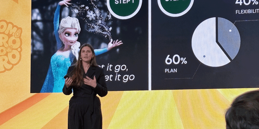 Keynote speaker Julia Bialetska standing in front of large presentation screen at a conference.
