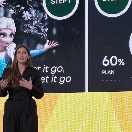 Keynote speaker Julia Bialetska standing in front of large presentation screen at a conference.
