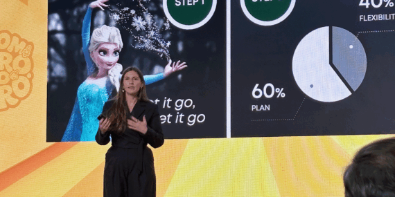 Keynote speaker Julia Bialetska standing in front of large presentation screen at a conference.