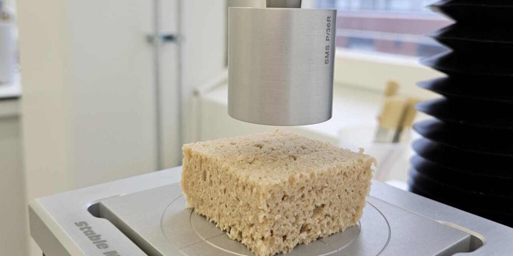 Pala kauraleipää, jonka päällä metallinvärinen lieriönmuotoinen analyysilaitteen osa.