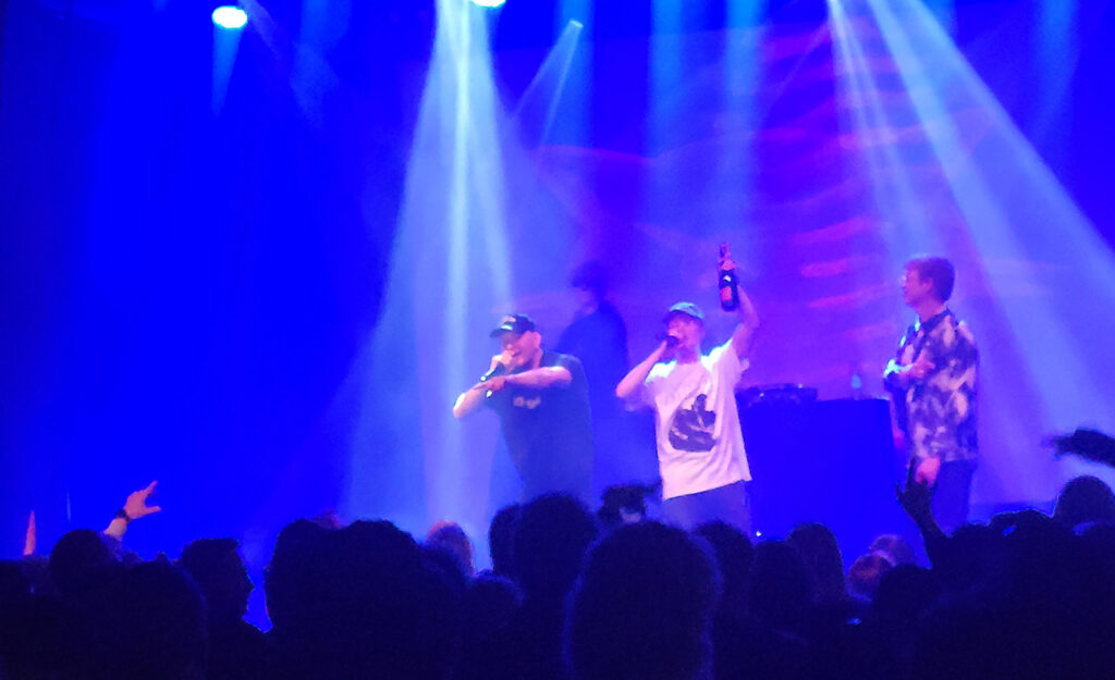 [Alt-teksti: esiintyjiä esiintymislavalla musiikkitapahtumassa.]