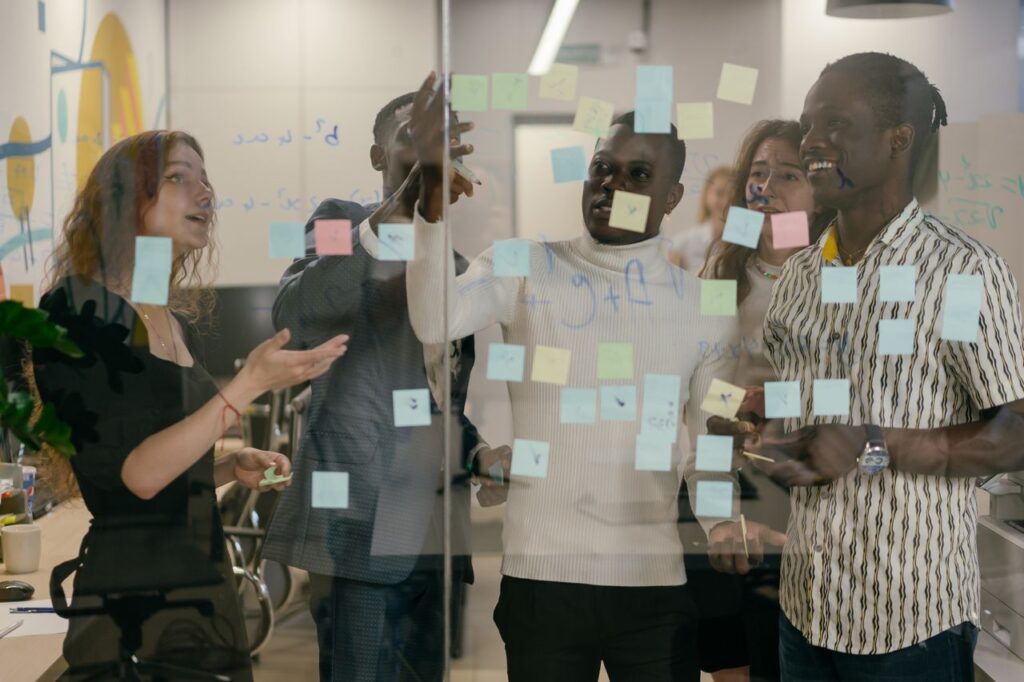 Ihmisiä kehittämistyöpajassa post it -lappuja tarkastelemassa